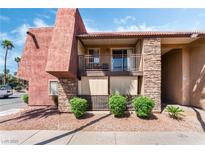 A cozy exterior view showing a two-story condo with stone accents, balcony, and well-kept landscaping at 5020 Indian River Dr # 424, Las Vegas, NV 89103