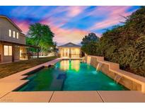 Beautiful backyard pool with waterfall features and ambient lighting, perfect for relaxation at 6335 Iginlas Goal Ave, Las Vegas, NV 89131