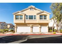 Inviting townhome featuring a multi-car garage and classic desert landscaping, perfect for a low-maintenance lifestyle at 6576 Buster Brown Ave # 101, Las Vegas, NV 89122