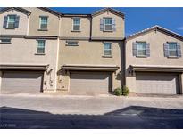 Three modern townhomes feature beige exteriors, symmetrical windows, and attached garages, offering comfortable urban living at 664 Foam Flower Ln, Henderson, NV 89015