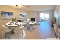 Bright living room features a fireplace, light wood floors, modern decor, and sliding glass doors at 6853 Tamarus St # 202, Las Vegas, NV 89119