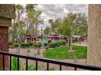 View of the community pool featuring a lush green landscape, mature trees and shaded seating areas at 7885 W Flamingo Rd # 2005, Las Vegas, NV 89147