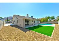 Spacious backyard featuring gravel landscaping, a grassy area, and a refreshing swimming pool under a clear sky at 1719 Rolling Hills Dr, Las Vegas, NV 89156