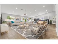 Open-concept living room featuring modern decor, hardwood floors, and a view of the kitchen at 2620 E Harmon Ave, Las Vegas, NV 89121