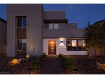 Charming two-story home with modern architectural design, brick walkway and manicured landscaping at twilight at 2650 Skylark Trail St, Henderson, NV 89044