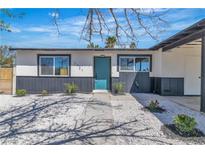 Charming single-story home with a teal front door and xeriscaped yard with small plants at 2721 Bruce Cir, North Las Vegas, NV 89030