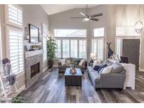 Bright living room featuring vaulted ceilings, wood floors, fireplace and lots of natural light at 53 Grossinger Ct, Henderson, NV 89074