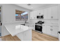 Modern kitchen featuring white cabinets, stainless steel appliances, and marble countertops at 8725 Russet Hills Ct, Las Vegas, NV 89147