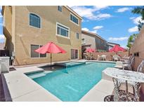 Inviting backyard pool with a hot tub, red umbrellas, and an outdoor seating area perfect for entertaining at 9742 Toad Hollow St, Las Vegas, NV 89141