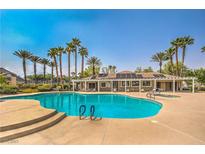 Resort-style pool with palm trees and covered seating area for relaxing and enjoying the outdoors at 10205 Birch Bluff Ln, Las Vegas, NV 89145