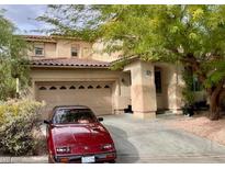 Inviting two-story home featuring a stucco exterior, a two-car garage, and mature landscaping in a desirable neighborhood at 11074 Caramel Crest Ct, Las Vegas, NV 89135
