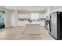 Bright kitchen features white cabinets, stainless steel appliances, and an island with marble countertop at 11074 Caramel Crest Ct, Las Vegas, NV 89135