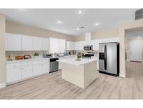 Bright kitchen featuring white cabinetry, stainless steel appliances, and a center island with a light countertop at 11074 Caramel Crest Ct, Las Vegas, NV 89135