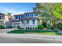 Charming two-story home with a well-manicured lawn and lush landscaping, creating a welcoming curb appeal at 1353 Volturno Way, Henderson, NV 89052