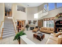 Spacious living room with high ceilings, fireplace, and large windows providing ample natural light at 1353 Volturno Way, Henderson, NV 89052