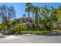 Stunning two-story home featuring mature landscaping, palm trees and lush green grass at 2008 Winter Wind St, Las Vegas, NV 89134
