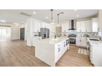 Bright, open kitchen features a waterfall island, stainless steel appliances, and modern finishes at 2581 Terrytown Ave, Henderson, NV 89052