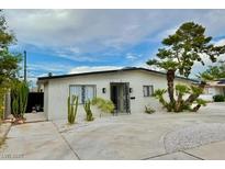 Charming single-story home featuring a desert landscaped yard, palm trees, and a concrete driveway at 3037 Holly Hill Ave, Las Vegas, NV 89104