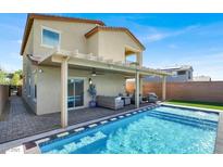 Inviting backyard oasis featuring a refreshing pool, covered patio, and comfortable outdoor seating area at 3136 Mossfield Ave, Henderson, NV 89052