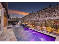 Inviting pool featuring a water feature and elegant landscaping at sunset at 33 Desert Juniper Ln, Henderson, NV 89011