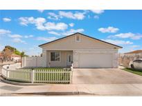 Charming home with a manicured front yard, white picket fence, and a paved driveway at 3409 Judson Ave, North Las Vegas, NV 89030