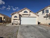 Charming single-story home with a two-car garage, tile roof, desert landscaping, and sunny skies at 3512 Trilogy Dr, Las Vegas, NV 89108