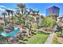 A luxurious community pool with waterfall feature, lounge chairs, and tropical landscaping at 4200 S Valley View Blvd # 3078, Las Vegas, NV 89103