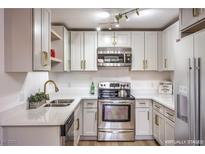 This updated kitchen has stainless steel appliances, light gray cabinets, and sleek white countertops at 5101 Village Dr, Las Vegas, NV 89142