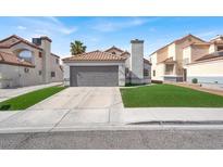 Charming home featuring a 2-car garage, red tile roof, and well-maintained artificial lawn at 5762 Yerington Ave, Las Vegas, NV 89110