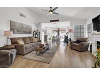 Bright living room with hardwood floors, ceiling fan and vaulted ceilings open to dining area at 656 Thornewood Pl, Las Vegas, NV 89123