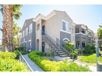 A well-maintained condo building featuring two-tone paint, landscaped grounds, and charming staircases at 10245 S Maryland Pkwy # 106, Las Vegas, NV 89183