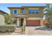 Two-story home with a two-car garage, desert landscaping, and a brick driveway at 10693 Harvest Green Way, Las Vegas, NV 89135