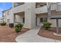 Beige two story condo with staircase, walkway and desert landscaping at 3318 N Decatur Blvd # 1043, Las Vegas, NV 89130