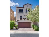 Charming stucco home featuring a two-car garage, manicured bushes, and well-maintained landscaping at 345 Gracious Way, Henderson, NV 89011