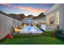 Beautiful backyard featuring pool, putting green, and outdoor entertaining area with mountain views at 38 Costa Tropical Dr, Henderson, NV 89011