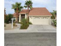 Charming home showcasing a well-manicured yard with palm trees and a two-car garage at 390 Rushing Creek Ct, Henderson, NV 89014