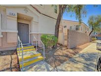 Inviting front entrance features a gray door with a small porch and yellow-trimmed steps at 6433 Buck Jones Ave # 102, Las Vegas, NV 89122