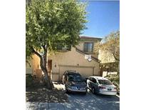 Inviting home featuring a two-car garage, mature shade tree, and neutral stucco exterior at 6531 Goldfield St, North Las Vegas, NV 89084