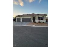 Charming single-story home featuring a three-car garage, tile roof, and low maintenance desert landscaping at 92 Hawk Ave, Pahrump, NV 89060