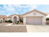 Charming single-story home with a two-car garage, desert landscaping, and a tile roof at 10029 Netherton Dr, Las Vegas, NV 89134