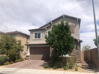 Charming two-story home showcasing a stone facade and a well-manicured lawn at 1064 Blue Wine Ct, Henderson, NV 89002