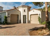 Elegant home featuring a two-car garage, desert landscaping, and a paved driveway at 11830 Kingsbarns Ct, Las Vegas, NV 89141