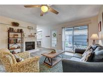 Inviting living room featuring a ceiling fan, fireplace, and sliding glass door to the patio at 227 N Lamb Blvd # B, Las Vegas, NV 89110