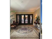 Elegant lobby with custom mosaic tile flooring, stylish seating, and ornate wrought iron doors at 30 Via Mantova # 109, Henderson, NV 89011