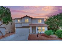Two-story home with a well-maintained front yard, two-car garage, and a red tile roof at sunset at 4909 Cherokee Run Ct, Las Vegas, NV 89131