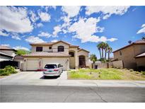 Charming two-story home with a large front yard, three car garage, and a sunny blue sky at 5412 Rainbows End Dr, Las Vegas, NV 89149