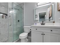 Modern bathroom features a glass shower, sleek vanity with illuminated mirror at 709 Jonathan Glen Way, Las Vegas, NV 89145