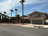 Charming two-story home featuring a well-manicured front yard and an attached two-car garage at 893 Fairway Dr, Boulder City, NV 89005