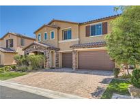 Inviting two-story home featuring stone accents, a brick driveway, and a two-car garage at 12296 Kings Eagle St, Las Vegas, NV 89141