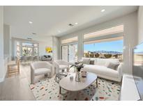 Bright living room with large windows and modern decor, seamlessly flowing into the dining area at 2904 Bow Bridge Dr, Las Vegas, NV 89134